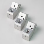 3 CNC-bearbeitete Gehäuse aus Metall, die nebeneinander liegen – Fertigung nach Kundenzeichnung.